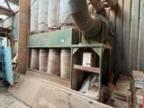 une grande machine qui se trouve dans un bâtiment où sont entreposés de nombreux rouleaux de papier