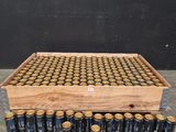une caisse en bois contenant des canettes de bière, posée par terre