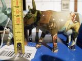 deux figurines représentant un taureau et une vache posées sur une table bleue