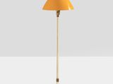 a yellow floor lamp on a white surface with a white background