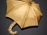 une photo d'une broche en forme de parapluie en or et diamants