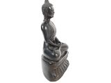 an image of a statue of a woman sitting on top of a rock