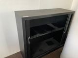 a small black cabinet with a bunch of items inside of it