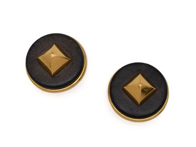 une paire de boucles d'oreilles à clous noires et dorées sur fond blanc