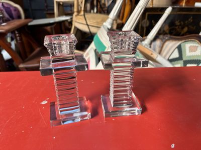 deux bougeoirs en cristal posés sur une table rouge