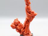 une statue orange représentant une femme tenant un panier de fleurs