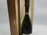 La bouteille de champagne se trouve dans la boîte posée sur la table.