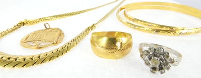 a lot of gold jewelry on a white surface