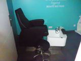 une chaise noire posée devant un mur bleu