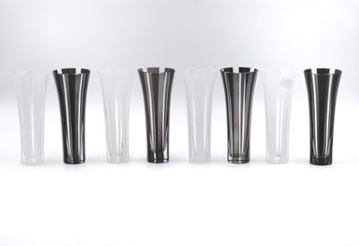 six vases noirs et blancs alignés sur une surface blanche