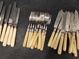 several forks and knives are lined up on a table