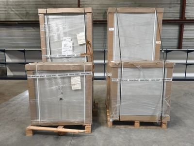 trois palettes de verre sont empilées sur des palettes dans un entrepôt