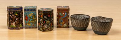 four small vases sitting next to each other on a table