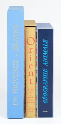 trois livres sont empilés sur une surface blanche