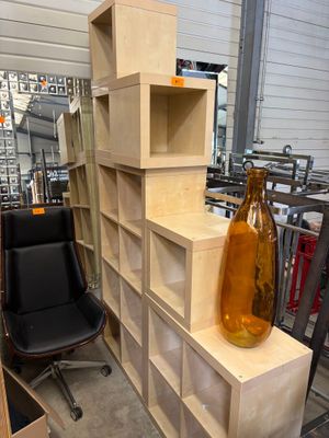 un vase posé sur une étagère en bois, à côté d'une chaise