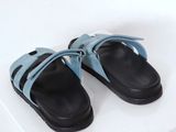 pair of black and blue sandals on a white surface with a white background