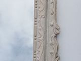 a mirror that is hanging on the wall with clouds in the background