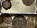 une boîte en métal contenant des pièces de monnaie, posée sur une table