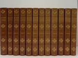 six livres marron sont alignés les uns à côté des autres sur une surface blanche