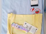 yellow and blue t - shirt and a pair of scissors on a table