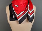 a red and black scarf on a mannequin torso