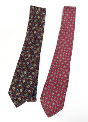 two ties with different designs on them on a white surface