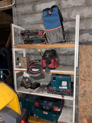 une étagère dans un garage, sur laquelle sont posés des outils