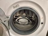 un gros plan d'une machine à laver dont la porte est ouverte