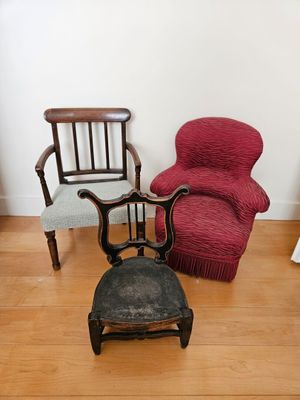 two chairs and a foot stool in the corner of a room
