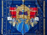 un gros plan sur une écharpe bleue et dorée ornée d'une couronne