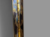 a close up of a gold and black sword on a gray background