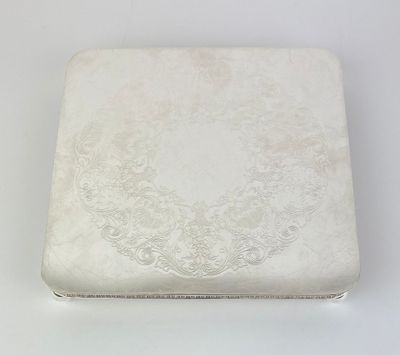 une boîte ancienne en argent avec un motif floral sur le couvercle