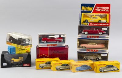 plusieurs petites voitures dans leurs boîtes et des cartons posés sur une surface blanche