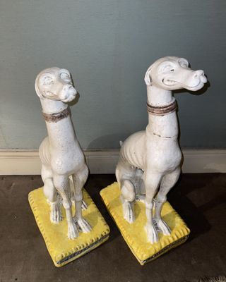two statues of animals that are sitting on a yellow mat