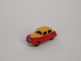 une petite voiture miniature posée sur une surface blanche