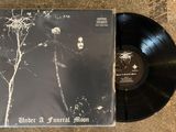 a black vinyl album with a picture of a man standing in front of a tree
