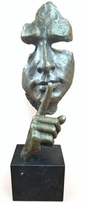 statue of a man ' s face with a finger on his lips