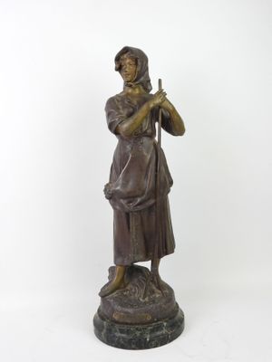 bronze statue of a woman with a bird on her shoulder