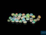 a close up of a bunch of white oplite beads on a black surface