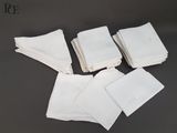 six serviettes blanches sont empilées les unes sur les autres sur une table