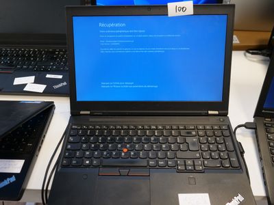 two laptops sitting on a desk with a blue screen