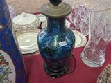 a blue vase sitting on a table with a red table cloth