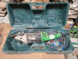 une boîte à outils verte contenant des outils, posée sur une table