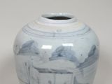 un vase bleu et blanc posé sur une surface blanche