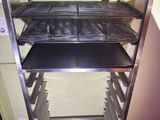 a metal rack with trays on it in a kitchen