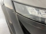 a close up of a car ' s headlight with a reflection of a building in the background