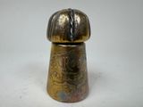 a small metal object on a white surface