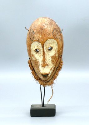 une photo représentant une sculpture représentant un masque posé sur un socle