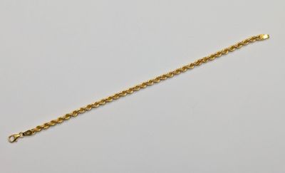 a gold chain bracelet with a heart charm on a white background