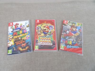 trois jeux Nintendo Wii posés sur un canapé